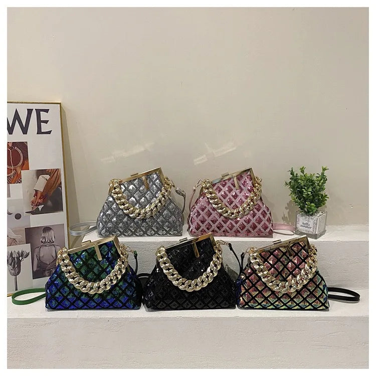 Five handbags with decorative chains on a white surface against a light gray wall.
