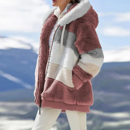 Person wearing a pink sherpa jacket with a mountainous background