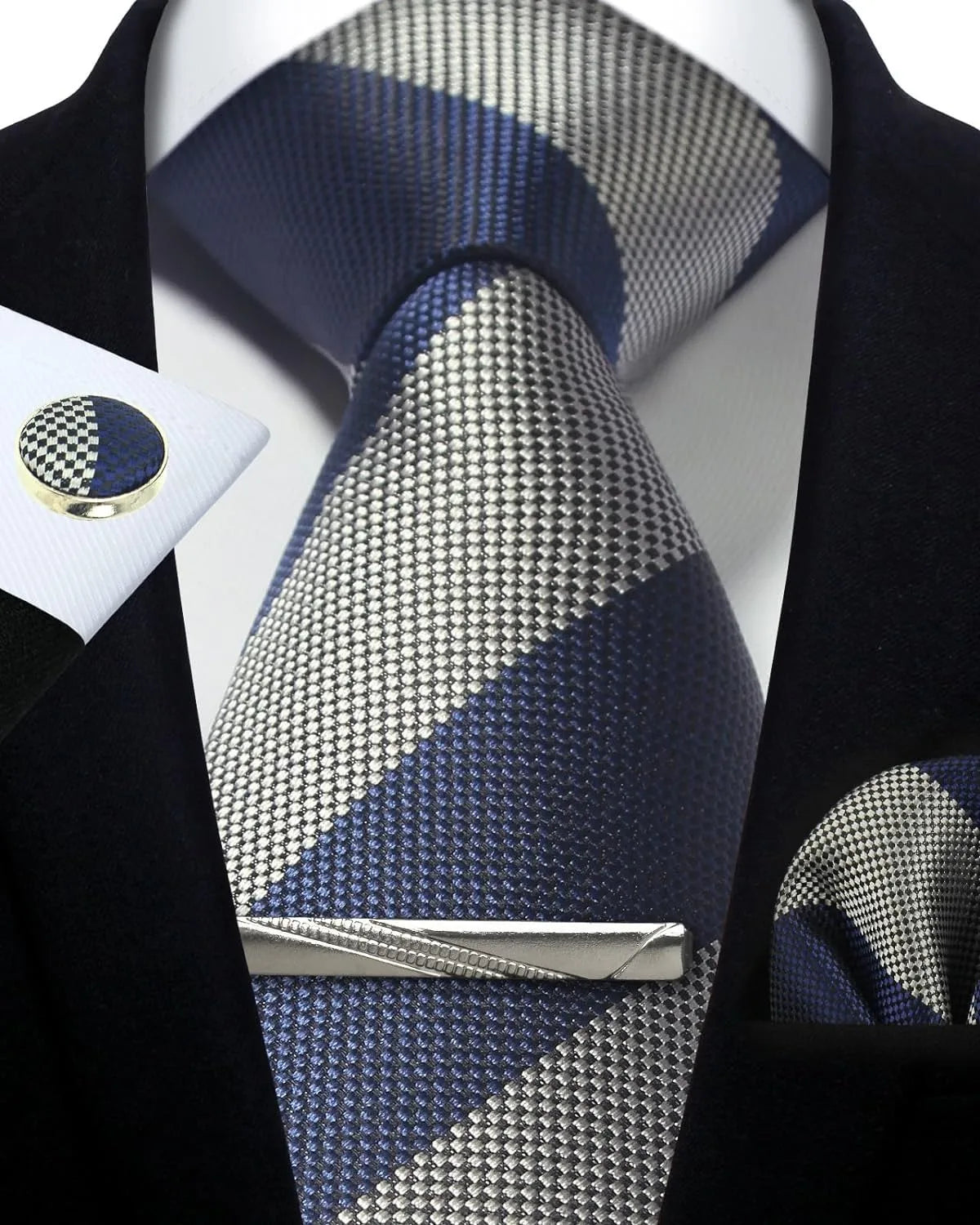 Navy and silver patterned tie with matching pocket square and cufflinks on a black suit.